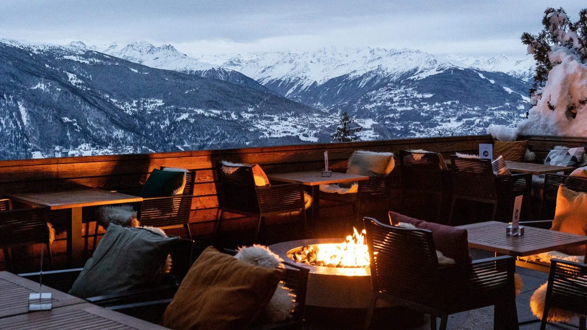 暮色中的 La Terrasse Valaisanne,火盆已点燃,对面是白雪覆盖的阿尔卑斯山